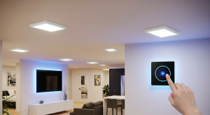 Hand adjusting a smart lighting control panel in a modern living room.